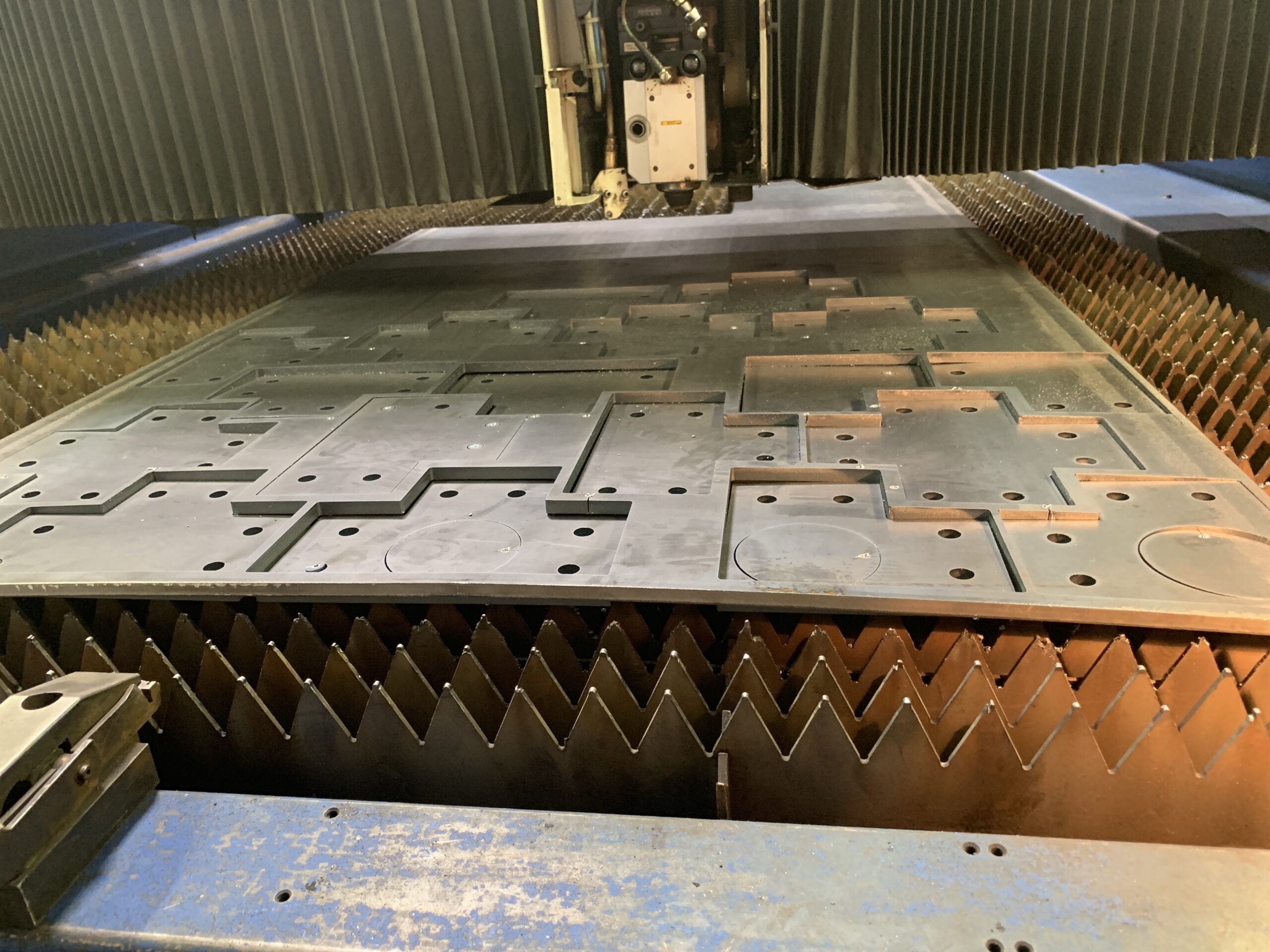Lit de découpe laser avec pièces industrielles rectangulaires découpées et trous de fixation – AC RIS Industrie